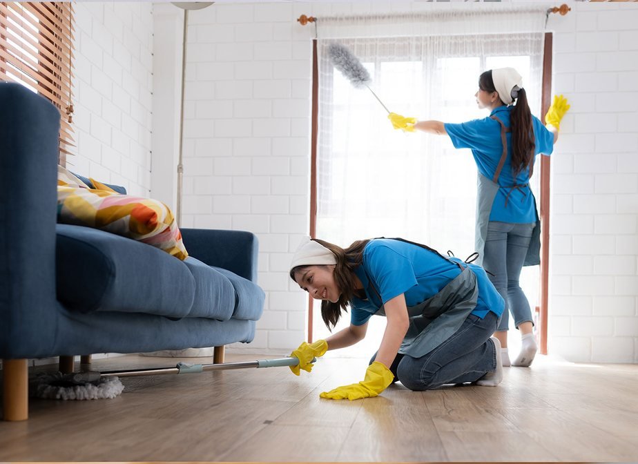 Two cleaners dusting and mopping a bright living room